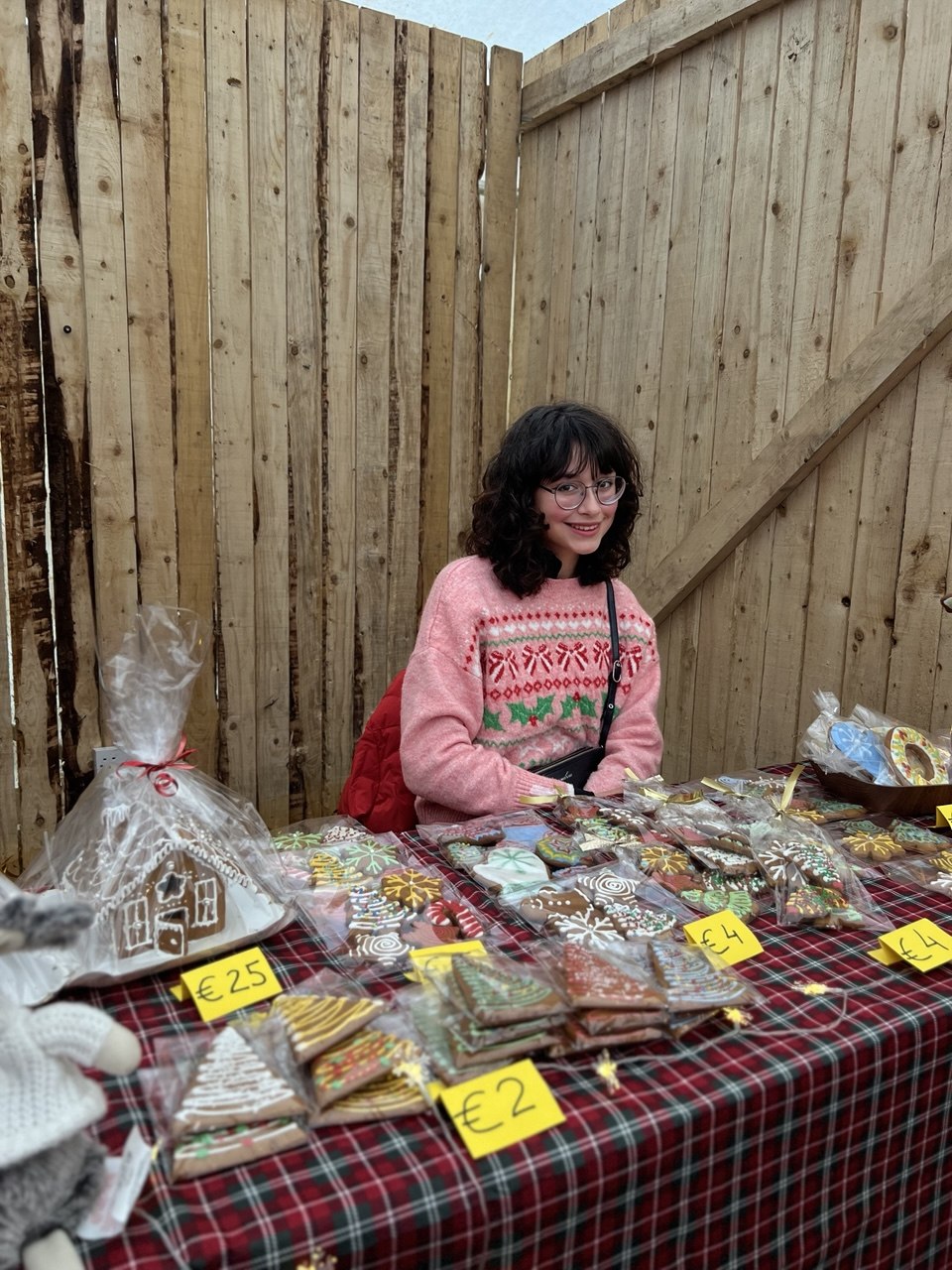 A girl with hand-iced gingerbread and a gingerbread house