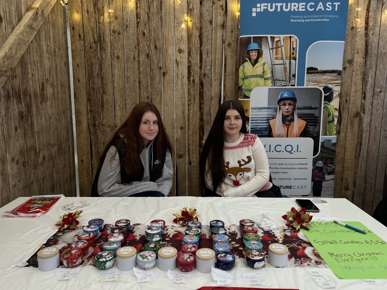 Two teenage girls with Christmas candles in decorated tins
