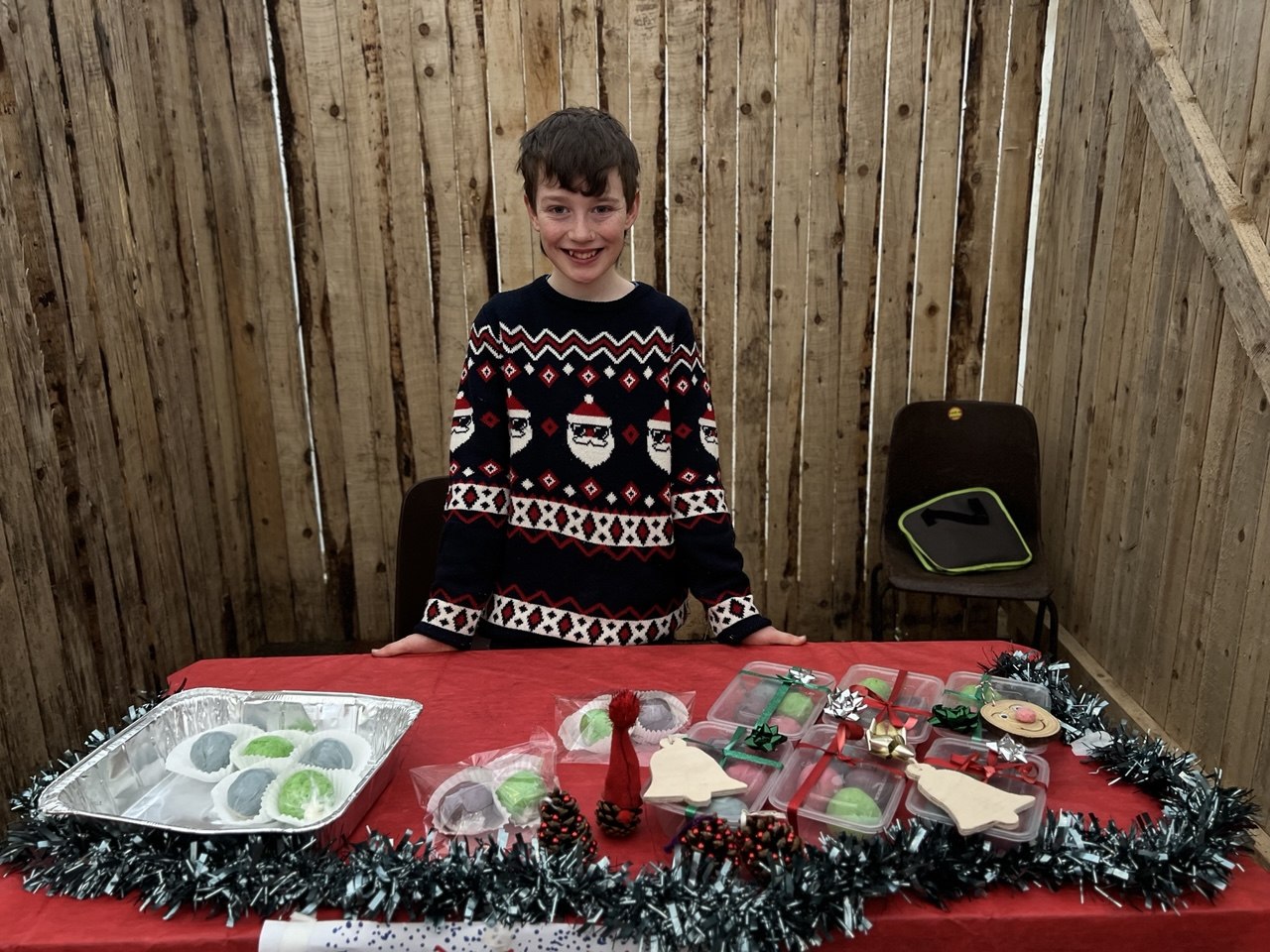 A smiling boy with homemade sweet treats in gift boxes
